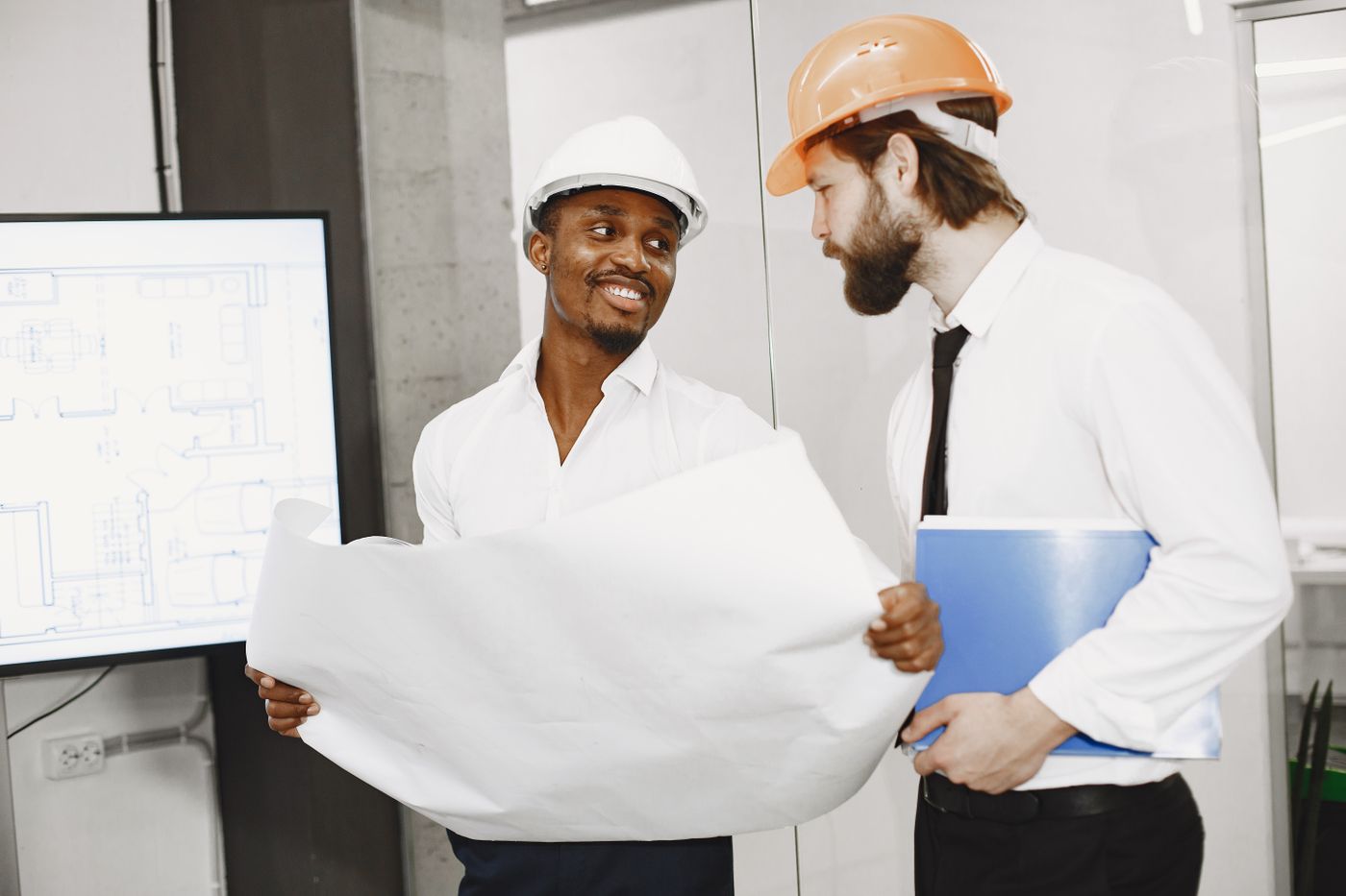 Deux professionnels du bâtiment consultant des plans de chantier
