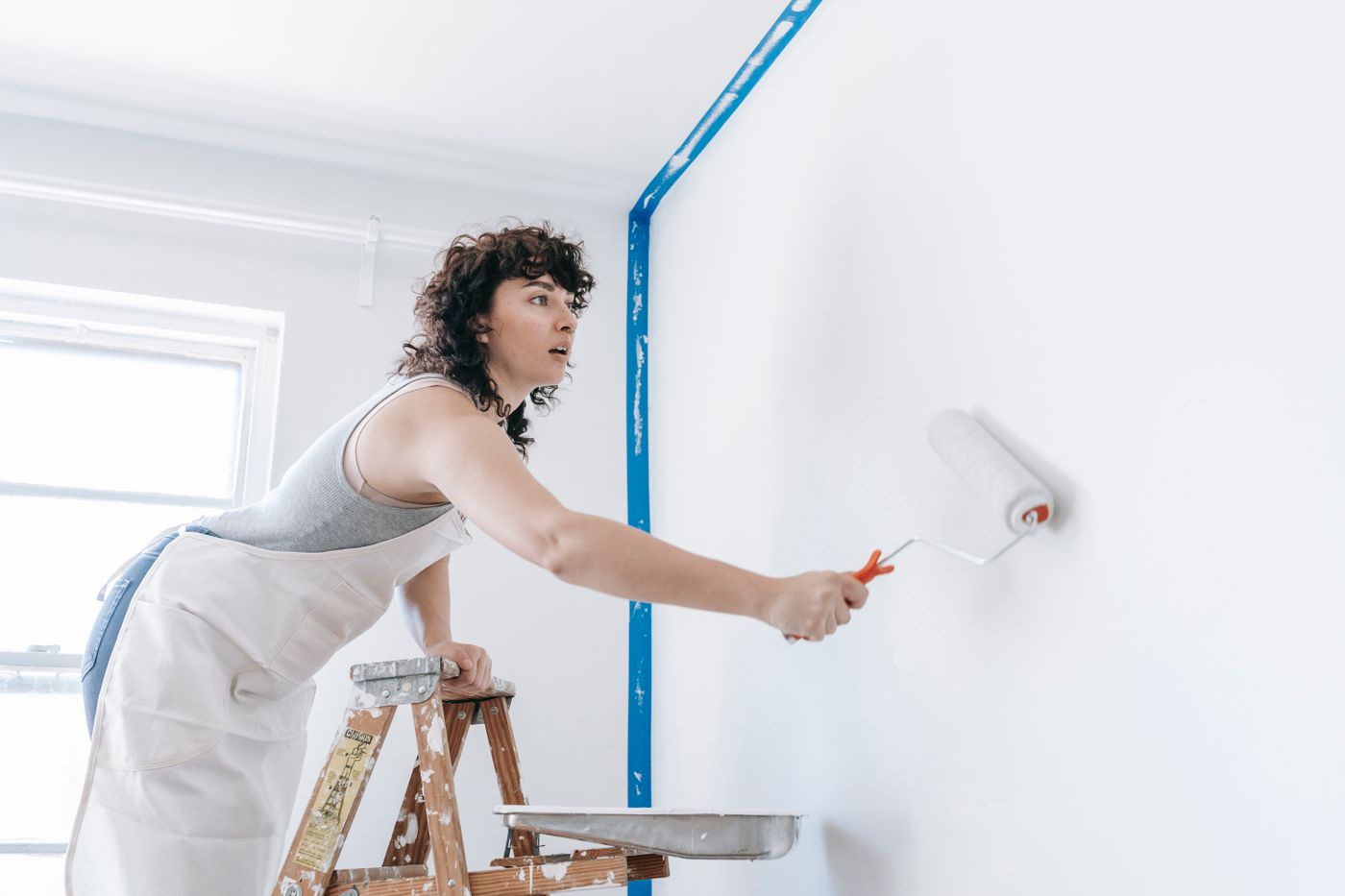 Artisan peintre appliquant de la peinture sur un mur intérieur